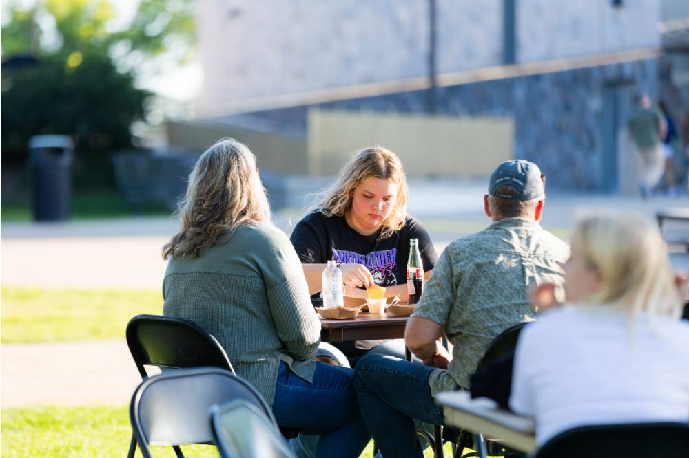 Family eating at table on Kirkhof Lawn.